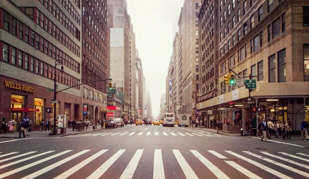 Busy New York streets with tall buildings and pedestrian crosswalks in the cityscape