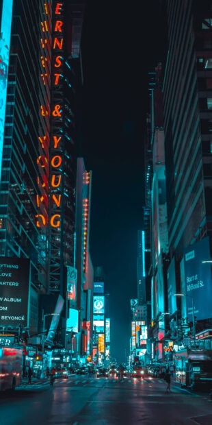 Night view of New York streets with bright city lights and tall buildings