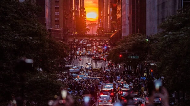 Crowds gather on New York street during sunset New York sunset