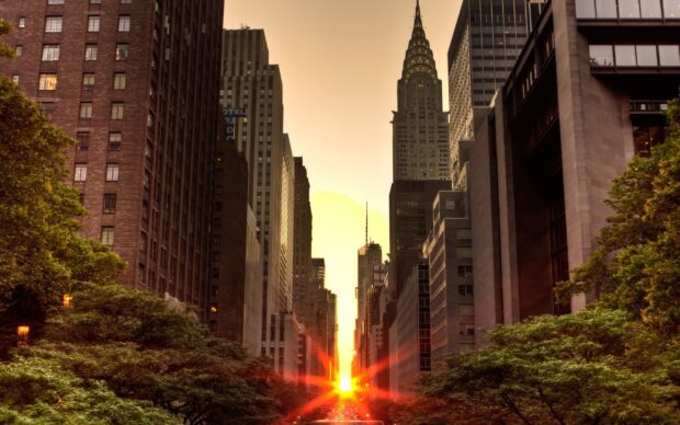 The vibrant New York sunset aligns perfectly with city skyscrapers and chrysler building silhouette