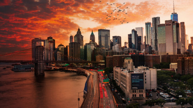 A vibrant New York skyline with sunset clouds and city traffic during golden hour