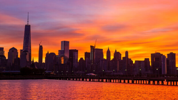New York city skyline with sunset colors reflecting over the water at dusk