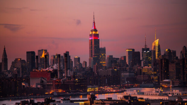 New York skyline during vibrant sunset with glowing lights and colorful sky