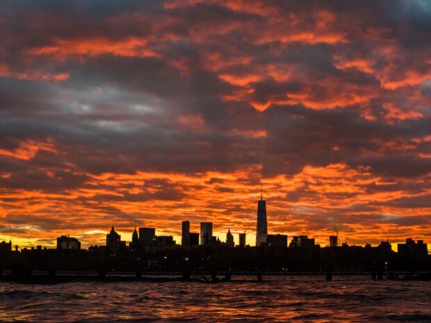New York sunset lit sky with city skyline and water in foreground