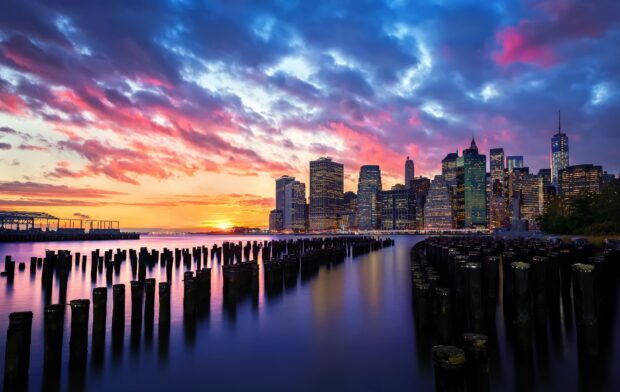 New York sunset with colorful sky over the city skyline and calm river at dusk