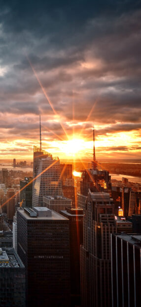 Stunning New York sunset with sun rays shining over skyscrapers and skyline