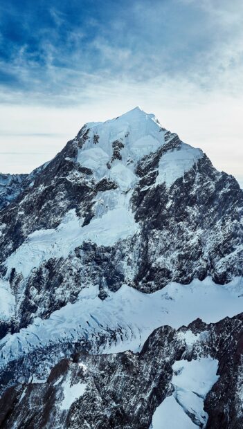 Snow covered mountain peak in New Zealand with clear blue sky