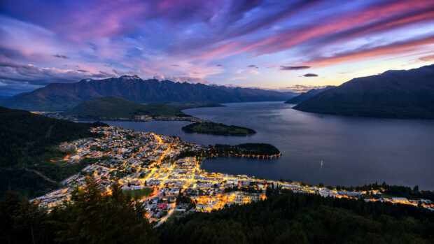 A vibrant evening view of New Zealand town with mountains and lake in the background