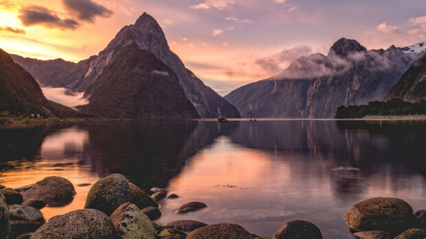 Rock filled lake with mountain landscape at sunset in New Zealand