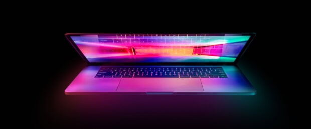 A glowing notebook displaying vibrant colorful lights reflecting on the keyboard and screen