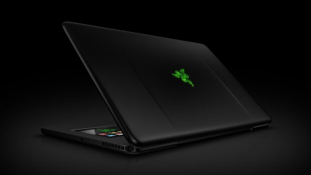 Black notebook with green glowing logo on the lid in a dark setting