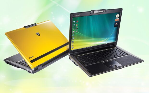 Yellow and black Asus notebook with its screen open and another closed against a light green background