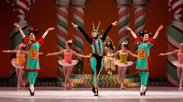 Ballet dancers performing a Nutcracker scene with colorful costumes on stage