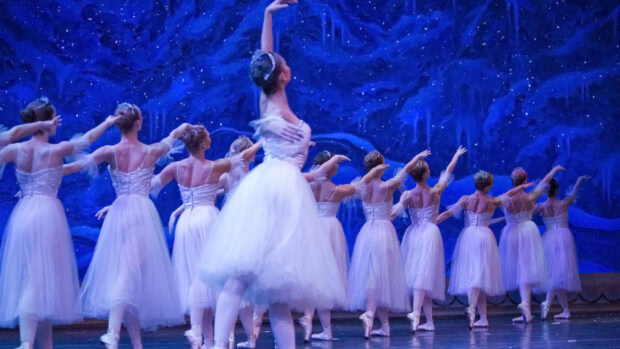 Ballet dancers performing in a scene from the Nutcracker ballet on stage