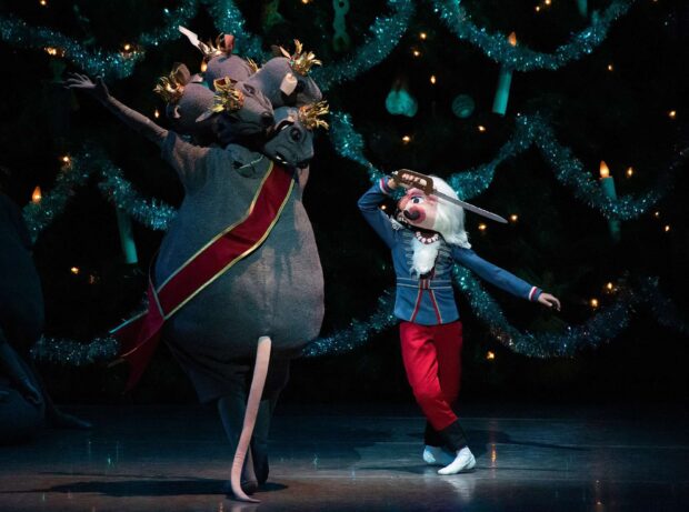 The nutcracker character dancing with the mouse king in a theatrical performance