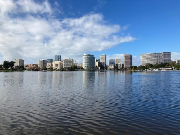 A clear view of Oakland city skyline featuring modern buildings across the water