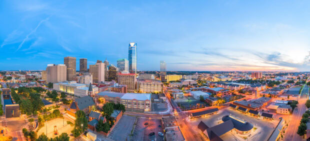 A panoramic view of Oklahoma City skyline showcasing modern skyscrapers and city lights at dusk