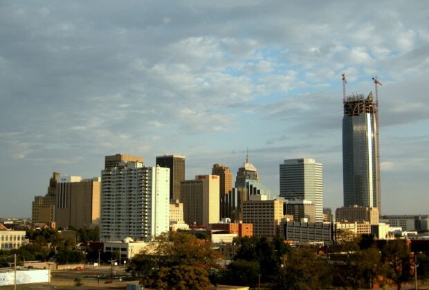 Oklahoma City skyline featuring tall buildings and a construction tower under a cloudy sky
