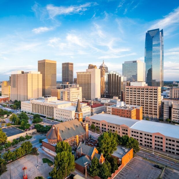 A clear view of Oklahoma City skyline with tall buildings and a church in golden hour light