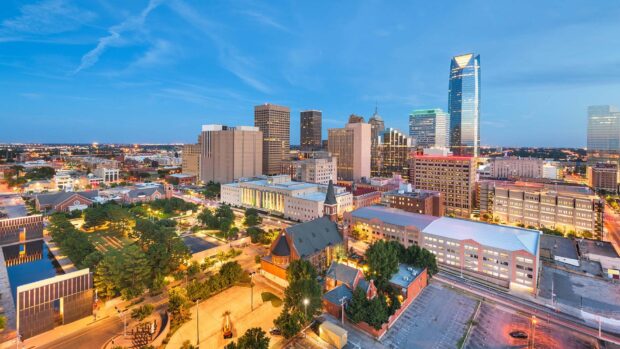 Oklahoma City skyline features modern skyscrapers and historic buildings under a clear blue sky