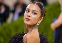 Olivia Rodrigo wearing a black feather dress with stunning earrings at a public event