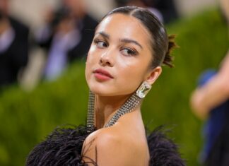 Olivia Rodrigo wearing a black feather dress with stunning earrings at a public event