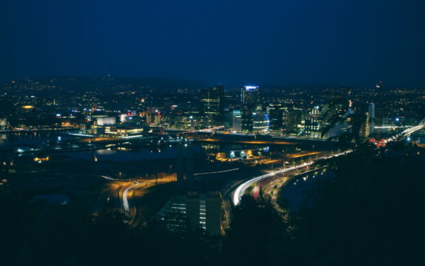 Night cityscape in Oslo showing illuminated buildings and traffic lights