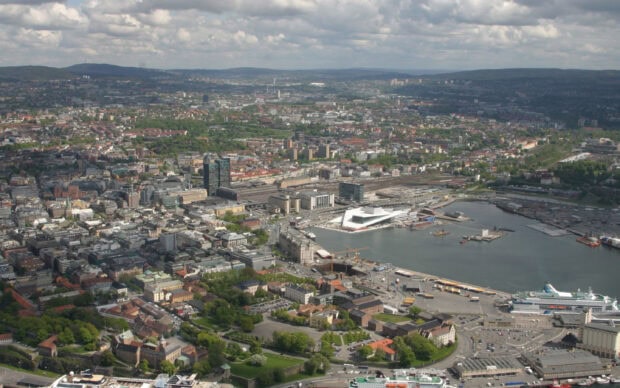 A panoramic view of Oslo cityscape featuring urban architecture and harbor area in clear daylight