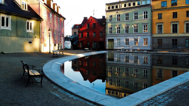 Colorful buildings reflected in a calm pond in Oslo city center reflecting Oslo