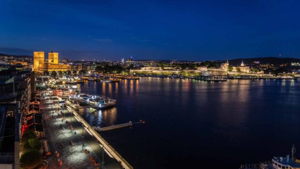 Oslo cityscape at night with illuminated buildings and waterfront views