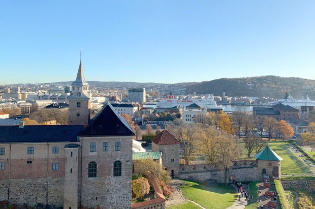 Historic oslo castle with cityscape and harbor in the background during autumn