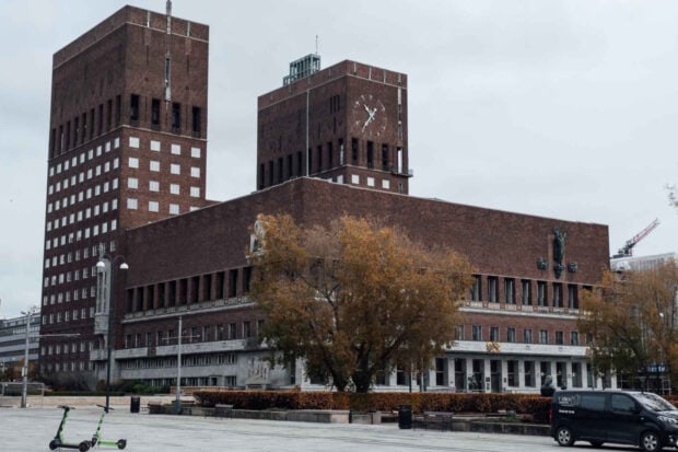 Historic Oslo City Hall with clock towers and autumn trees in autumn setting