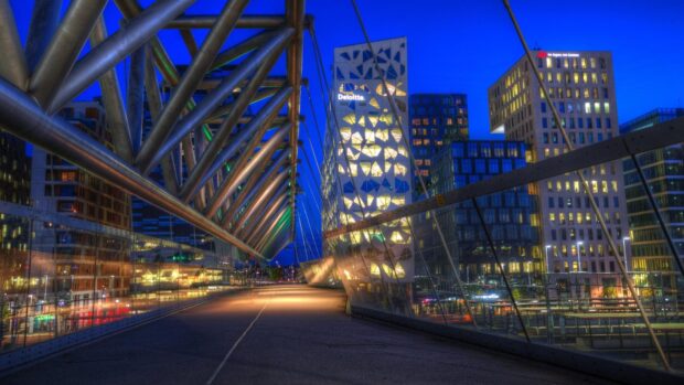 Modern Oslo architecture and Deloitte building lit up at night with structural bridge details