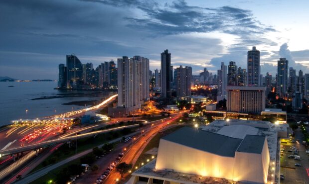 Panama City skyline with illuminated buildings and busy roads at dusk