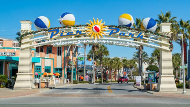 The entrance arch to Panama City Pier Park with colorful beach balls and palm trees