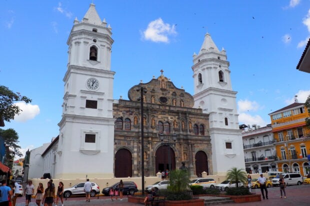 Historic church towers and statues in Panama City with clear blue sky and pedestrians   Copy