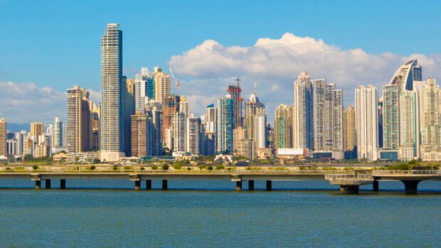 Panama City skyline with high rise buildings and calm water under blue sky