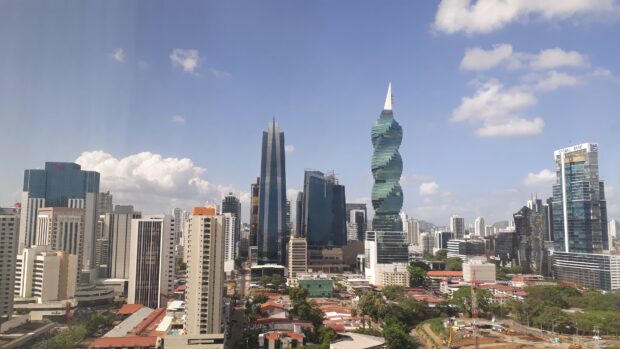 A panoramic view of Panama City skyline featuring modern skyscrapers and urban buildings on a sunny day