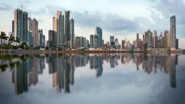 High rise buildings of Panama City reflecting on calm water at dawn