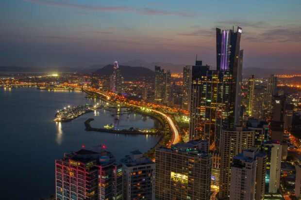 Night view of Panama City skyline with illuminated buildings and waterfront