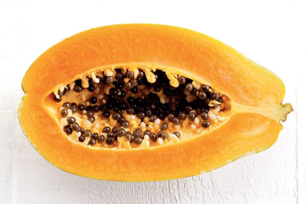 Fresh papaya fruit cut open showing seeds and vibrant orange flesh