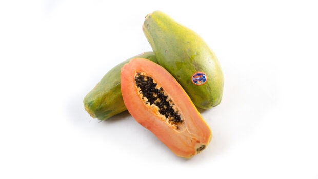 Fresh papaya fruit with seeds displayed on a white surface