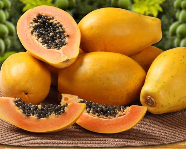 Fresh ripe papaya with seeds cut open on a table