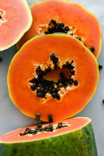 Fresh ripe papaya with vibrant orange flesh and black seeds inside the fruit