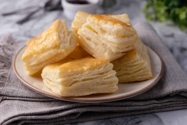 Flaky pastry pieces stacked on a plate showcasing layered pastry texture