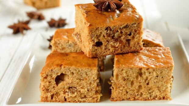 A close up of pastry slices with nuts on a white plate