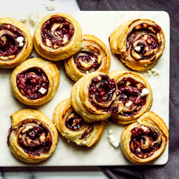 Delicious pastries with berry filling arranged on a white marble board