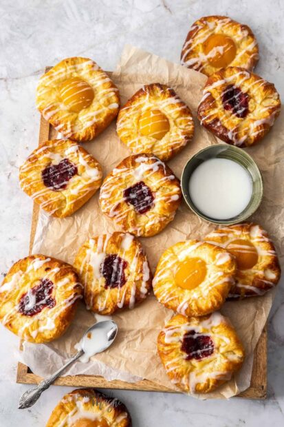 Fresh fruit pastries with apricot and raspberry filling on a wooden tray