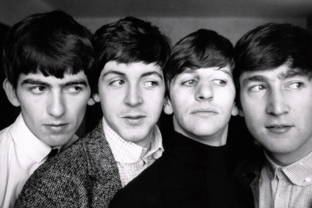 Young Paul Mccartney and bandmates in a classic black and white portrait looking sideways