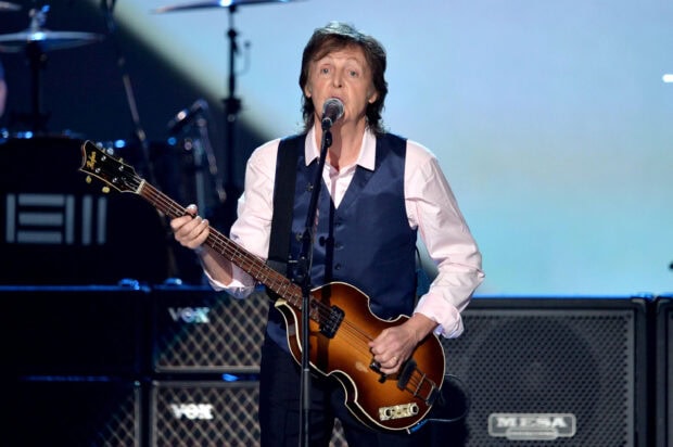 Paul Mccartney playing a guitar during a live music performance